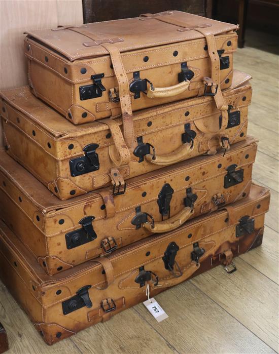 A stack of four pigskin suitcases, Largest W.75cm